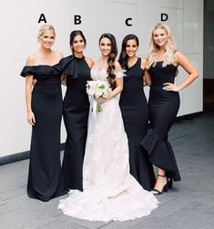 four bridesmaids in black dresses posing for a photo outside the building with their bouquets