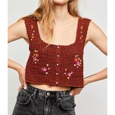 a woman with her hands on her hips wearing a crocheted cropped top