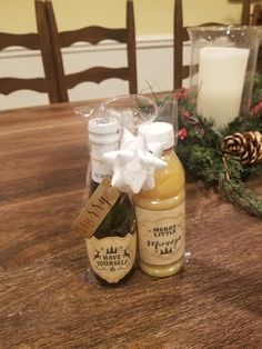 a bottle of honey sitting on top of a wooden table next to a pine cone