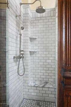 a walk in shower sitting next to a wooden door