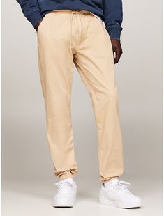 Tommy Hilfiger men's pant. Designed to be worn anywhere, these slim-cut, stretch-cotton twill joggers have the appeal of chinos with the comfort of a pair of sweats. Featuring an elastic drawstring waistband for ease of movement and simple branding for a touch of casual style. Part of our Tommy Jeans collection.  Material: 50% Organic Cotton, 47% Better Cotton Initiative, 3% Elastane. Casual Beige Cotton Joggers, Tommy Hilfiger Cotton Pants With Pockets, Casual Relaxed Fit Tommy Hilfiger Bottoms, Simple Branding, Jeans Collection, Tommy Hilfiger Man, Tommy Jeans, Drawstring Waistband, Stretch Cotton