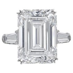 Elevate your style with this exquisite ring, a true embodiment of sophistication and elegance. At its heart, a resplendent 5-carat emerald-cut diamond takes center stage, displaying the enchanting interplay of light and facets. With a subtle I color and exceptional VS2 clarity, the diamond emanates a timeless beauty that captivates the senses. Flanking the majestic emerald-cut diamond are two tapered baguette diamonds, adding a touch of contemporary flair to the classic design. These diamonds co Harry Winston Diamond, Emerald Cut Diamond Engagement, Contemporary Engagement Rings, Emerald Cut Diamond Ring, Dream Party, Baguette Diamond Rings, Platinum Diamond Rings, Modern Engagement Rings, Engagement Ring Diamond Cut