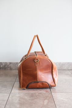 This leather & cowhide duffle bag with wheels is perfect for travelling. Stylish and convenient, it features an adjustable metal handle that locks into place for use while rolling the bag on the two fixed wheels. The handle can be pushed back inside, and zipped in, so that it's hidden when not in use. This duffle bag features zip closures with leather pulls. This duffle bag features two leather carrying handles (8 inches tall), a detachable & adjustable shoulder strap with shoulder pad for easy Duffle Bag With Wheels, Chinchilla Fur, Fur Blanket, Leather Pulls, Mink Fur, Earmuffs, Rabbit Fur, Fox Fur, Duffel Bag