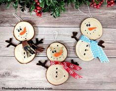 three wood slices with snowmen on them and christmas decorations hanging from the tree branches