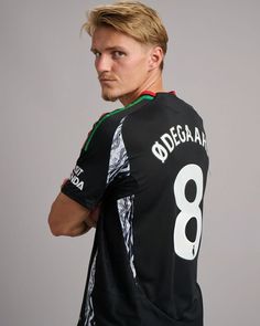 a man with blonde hair wearing a black jersey