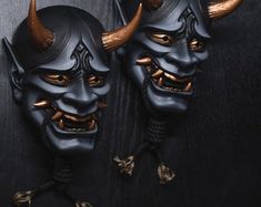 two black masks with horns on them sitting next to each other