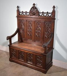 an old wooden bench with carvings on the back and seat is sitting against a wall