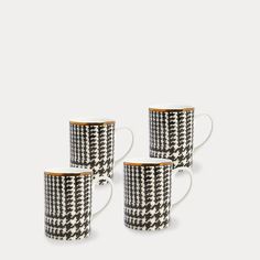 three black and white coffee cups with gold rims