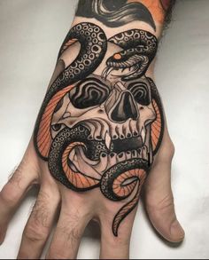 a hand with an octopus and skull tattoo on it