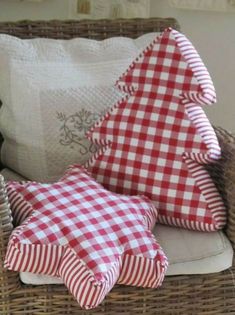 two red and white pillows sitting on top of a wicker chair next to each other