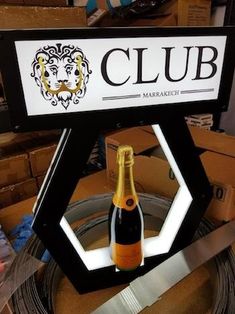 a bottle of wine sitting on top of a table next to a sign that says club