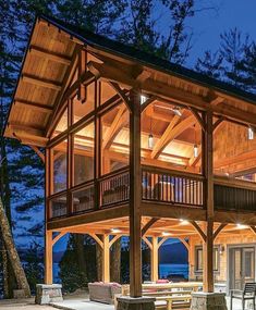 a large wooden building with lots of windows and lights on it's sides at night