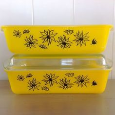 two yellow casserole dishes with black spider web designs