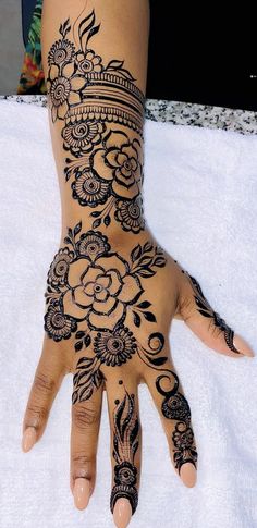 a woman's hand is decorated with hennap and flower designs on it