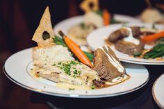 two white plates topped with different types of food