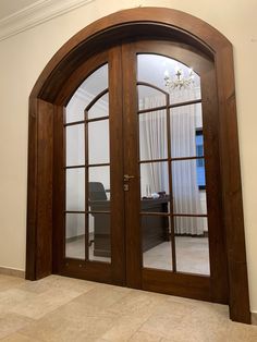 an arched wooden door with glass panels in a home office area that looks like it has been built into the wall