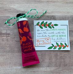 a tube of black cherry marzite next to a card with a green ribbon