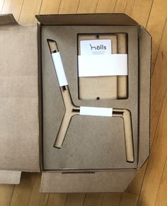 an open cardboard box with a pen in it