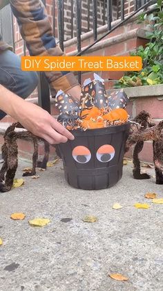 someone is decorating their halloween treat basket with fake bats and spider legs for the kids to put in