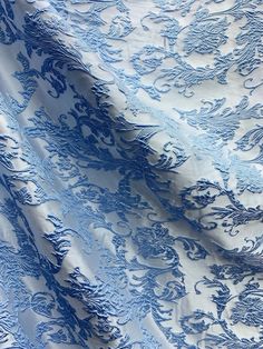 the blue and white fabric has intricate designs on it