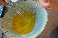 a person is whisking oil in a bowl