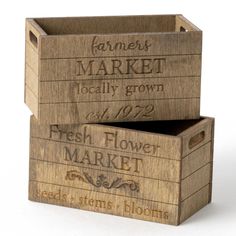 two wooden crates with labels on them sitting side by side in front of each other