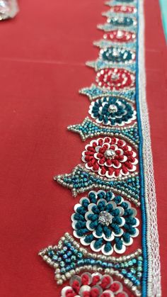 an embroidered table runner with red, white and blue flowers on the edge is shown