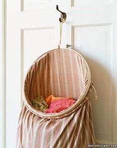 a hammock hanging from a door with clothes in the basket on it's side