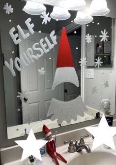 a bathroom mirror with an elf's hat on it and stars in the reflection