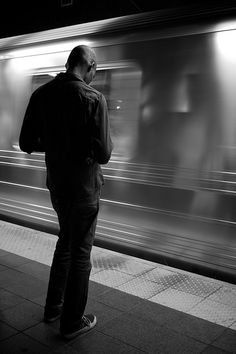 a man is waiting for the subway to arrive