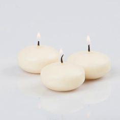 two white candles sitting next to each other