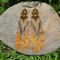 These stunning and sparkling Yawanawa earrings come from Aldeia Yawarany in Acre, Brazil. The Yawanawa are revered for their gorgeous beadwork and earrings. These items have been collected from the daughter of the Cacique, and the women of the village to raise money for the recent floods in Tarauaca. All earrings are one of a kind, hand made and take months to create. Product Description: 1.25'' width and 8'' inch dangling drop with ombre beads and sacred kene design. Jewellery Shoot, Beaded Earrings Native, Ankle Jewelry, Beaded Earring, Seed Bead Patterns, Light Earrings, Earring Ideas, Beading Tutorial, Golden Light