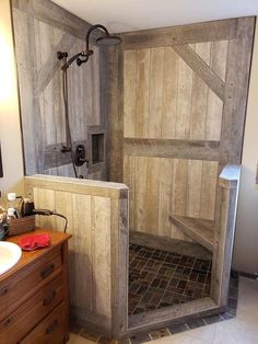 a bathroom with a wooden shower stall and tiled floor