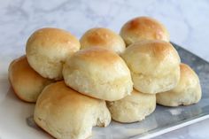 a pile of rolls sitting on top of a white plate