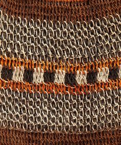 an orange and white knitted object with chains on it's sides, close up