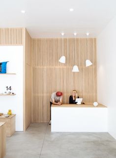 two people sitting at a counter in a room with wood paneling on the walls