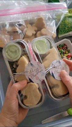 two hands holding small containers filled with food