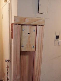 a bathroom with a wooden cabinet and toilet paper dispenser on the wall