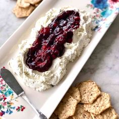 an appetizer plate with crackers and cranberry sauce