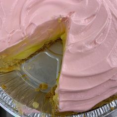 a cake with pink frosting and a piece missing from the pie pan that has it's slice taken out