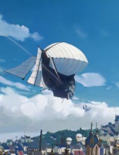 a large kite flying over a city under a blue sky with clouds in the background