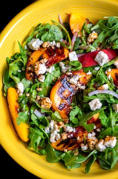 a salad with peaches, feta cheese and walnuts in a yellow bowl