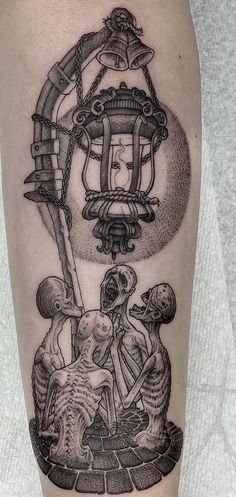 a black and white tattoo on the leg of a person with a lantern above them