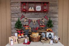 a table topped with cakes and desserts on top of wooden crates next to a wall