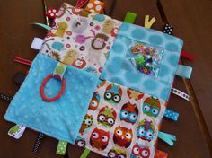 an assortment of baby's bibs and toys laid out on a table top