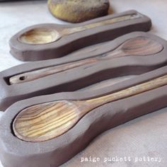 three wooden spoons sitting on top of a table