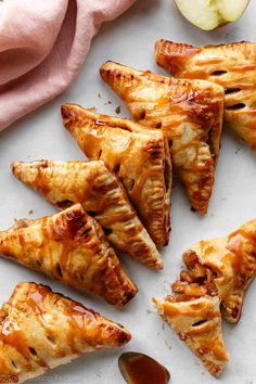 apple turnovers with caramel drizzled on them next to an apple