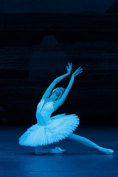 a ballerina in white tutu with her arms outstretched