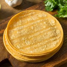 three tortillas sitting on top of a wooden cutting board