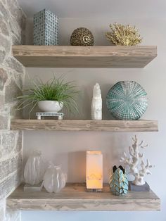 two wooden shelves with candles, vases and other decorative items on top of them